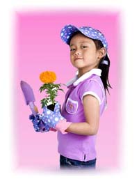 A cute 10 year old girl holding a marigold flower and a garden shovel.