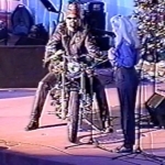 A man with sun glasses riding a Harley Davidson motorcycle on a church stage.